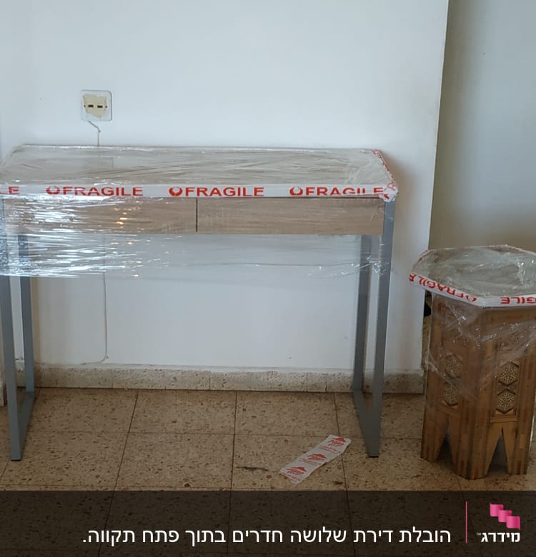 שולחן ושרפרף עטופים בניילון עם כיתוב 